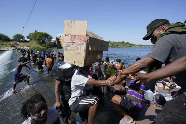 Người di cư Haiti băng qua một con đập để đến Mỹ từ Mexico ngày 17/9 ở Del Rio, Texas. (Ảnh: AP)