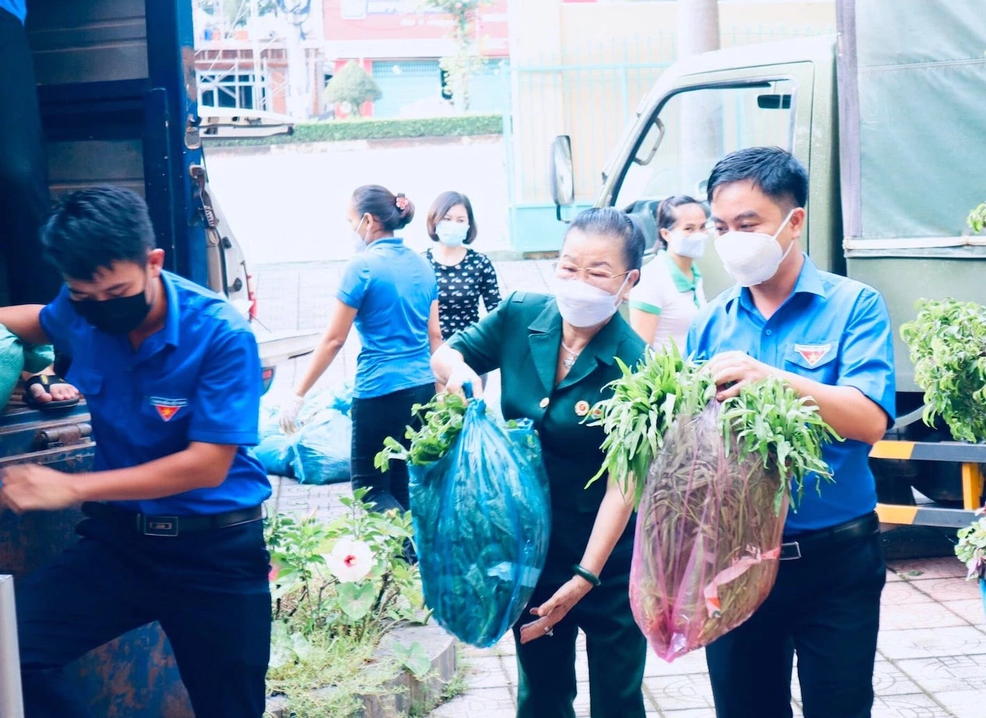 Bà Nguyễn Thị Hồng Tươi - Chủ tịch Hội Doanh nhân CCB tỉnh Bình Phước cùng các bạn trẻ vội khuân những bó rau xanh lên xe để kịp giờ khởi hành đến TP Hồ Chí Minh