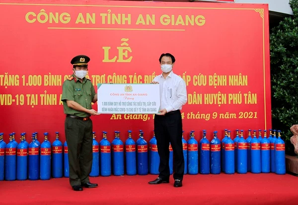 Đại tá Đinh Văn Nơi, Giám đốc Công an tỉnh trao Bảng tượng trưng tặng 1.000 bình oxy cho đồng chí Trần Quang Hiền, Giám đốc Sở Y tế  (1.000 bình oxy còn lại do Công ty Cổ phần đầu tư xây dựng Tấn Thắng ủng hộ).