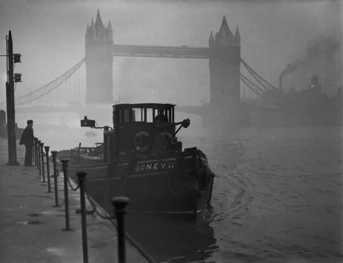 Tàu kéo trên sông Thames với cầu tháp nổi tiếng Tower Bridge phía sau trong một ngày sương mù ở London năm 1952.