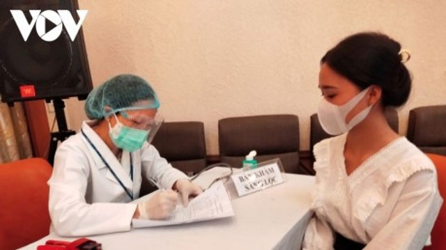Người dân tại TP Hồ Chí Minh khám sàng lọc trước khi tiêm vaccine