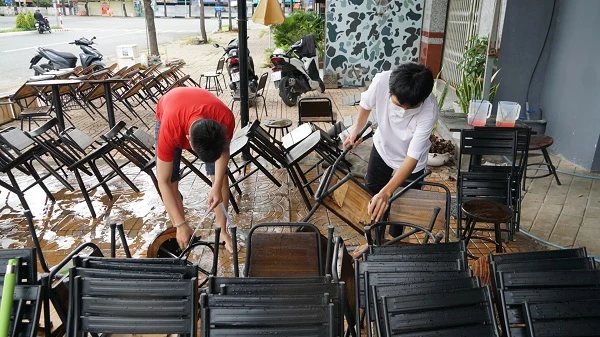 Một số quán cà phê vui vẻ rửa bàn ghế chuẩn bị hoạt động.