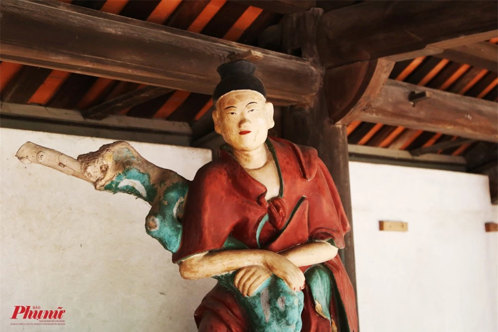 Cận cảnh một bức tượng La Hán trong chùa. Du khách cũng có thể nhìn thấy hệ thống kèo, cột gỗ rất to kiến tạo nên các gian của chùa.