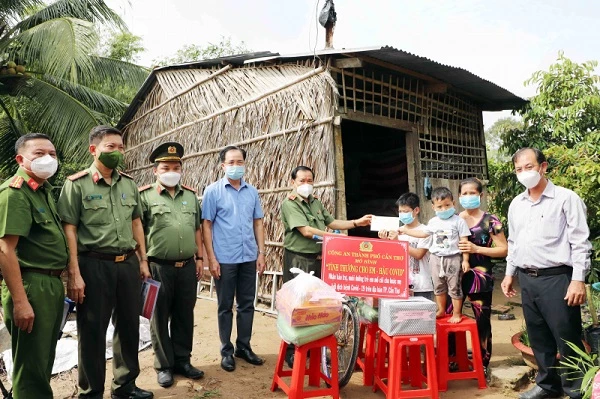 Công an TP Cần Thơ trao tiền và quà cho hai em mồ côi cha do dịch COVID-19.