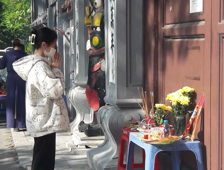 Theo quy định phòng chống dịch bệnh Covid-19 của UBND thành phố Hà Nội, các hoạt động tôn giáo, đình, chùa,… vẫn chưa được phép đón khách trở lại. Vì vậy, người dân phải đứng ngoài cổng vái vọng.