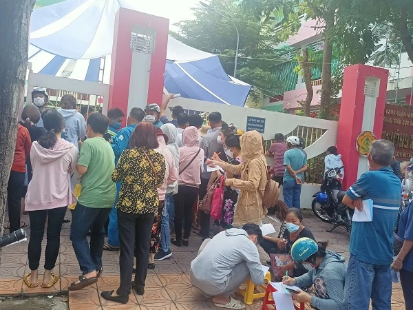 1.	Người dân chen chút nhau đông đúc ở cổng để giành tới lượt tiêm vaccine .