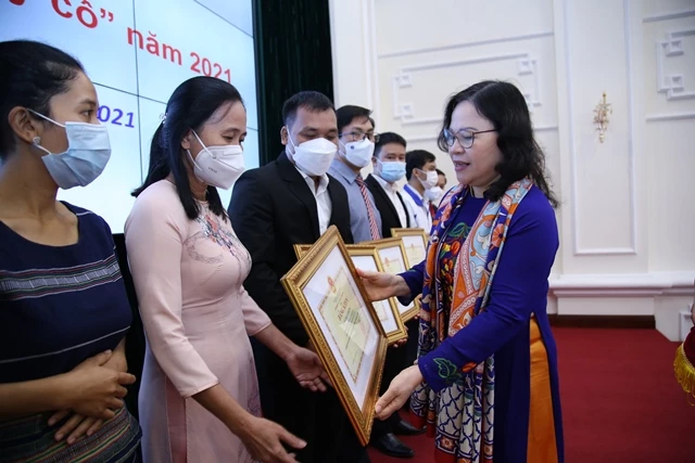 Thứ trưởng Bộ GD-ĐT Ngô Thị Minh (bên phải ảnh) tặng bằng khen tới các thầy cô giáo.