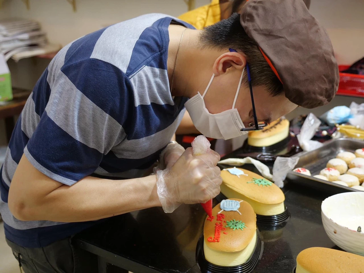 Anh Nguyễn Sỹ Hiền khéo léo viết những thông điệp cổ động chống dịch lên từng chiếc bánh