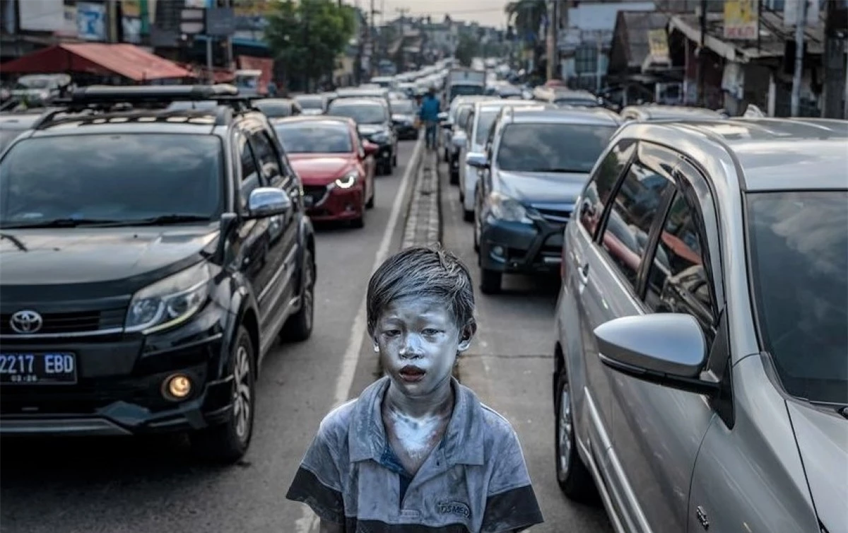 Cậu bé ở Indonesia, năm 2021.Cậu bé Aldi 8 tuổi, ăn xin trên đường phố Depok, Indonesia. Mặt bôi một hỗn hợp độc hại của sơn kim loại và dầu ăn, cậu bé biến thành một tác phẩm điêu khắc di động được trau chuốt. Aldi thuộc một nhóm người được gọi là Manusia Silver (hay "Người Bạc") sử dụng cách hóa trang nguy hiểm này để mưu sinh.