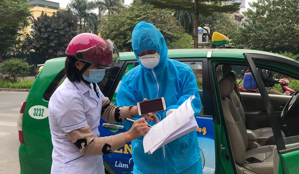 Cán bộ y tế phường bàn giao bệnh nhân cho lái xe taxi Mai Linh.