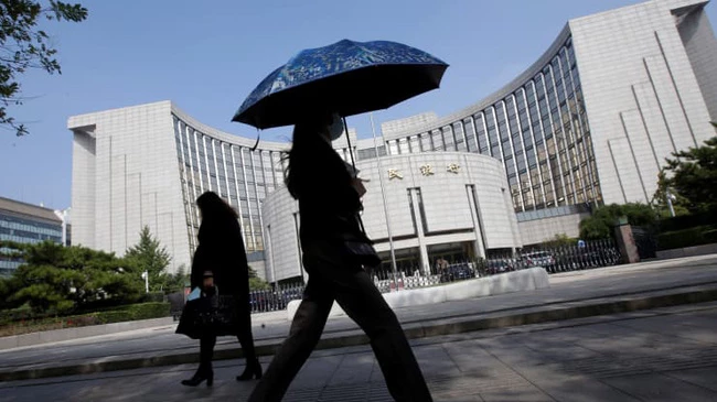 Người dân đi ngang qua trụ sở của Ngân hàng Nhân dân Trung Quốc (PBOC), ở Bắc Kinh. (Ảnh: Reuters)
