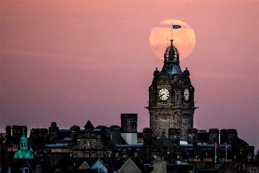 Trăng S&oacute;i dần lặn sau th&aacute;o đồng hồ Balmoral ở Edinburgh. Ảnh: Jane Barlow / PA.