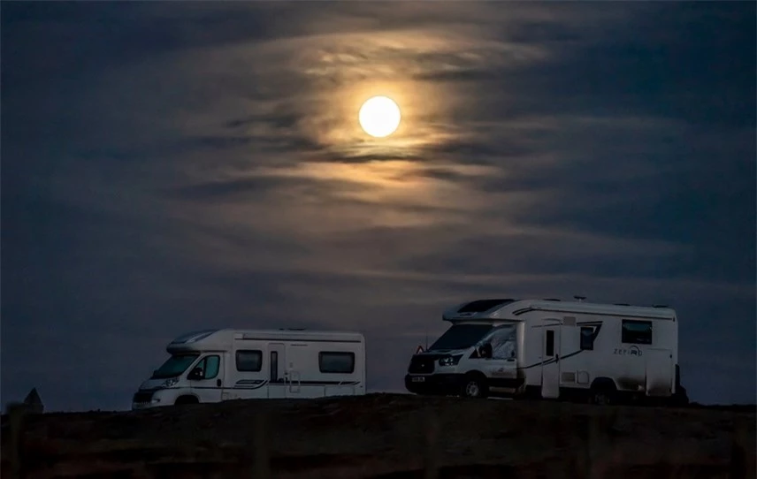 Mặt Trăng lặn sau một chiếc xe tải đậu trong c&ocirc;ng vi&ecirc;n quốc gia North York Moors ở Yorkshire. Ảnh: Danny Lawson / PA.