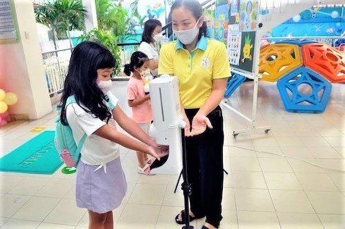 Học sinh được giáo viên hướng dẫn rửa tay bằng nước sát khuẩn trước khi vào lớp