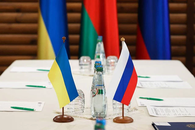 Quốc kỳ Ukraine (trái) và Nga tại bàn đàm phán ở Belovezhskaya Pushcha thuộc vùng Brest, Belarus. (Ảnh: TASS)