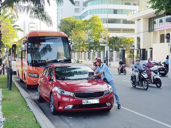 Dán thông báo thu phí đối với các xe ô tô sử dụng tạm thời lòng đường để đỗ xe ô tô trên hai tuyến đường Bạch Đằng, Trần Phú (Đà Nẵng)