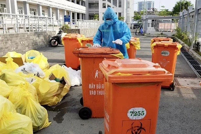 Công nhân vệ sinh thu gom, vận chuyển chất thải tại các cơ sở cách ly COVID-19. Ảnh: Hồng Giang - TTXVN