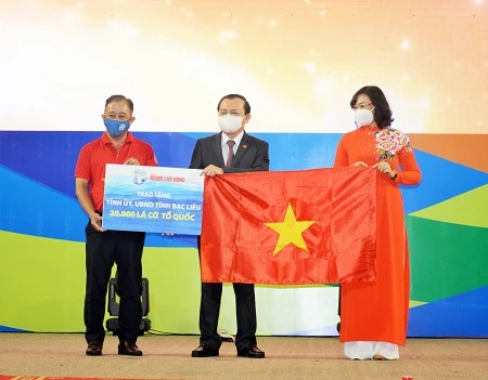 Bà Phan Thị Thắng, Phó Chủ tịch UBND TP HCM và ông Bùi Thanh Liêm (bìa trái), Phó Tổng Biên tập Báo Người Lao Động trao cờ Tổ quốc và bảng tượng trưng 20.000 lá cờ cho ông Lê Tấn Cận, Phó Chủ tịch UBND tỉnh Bạc Liêu.                                                                      