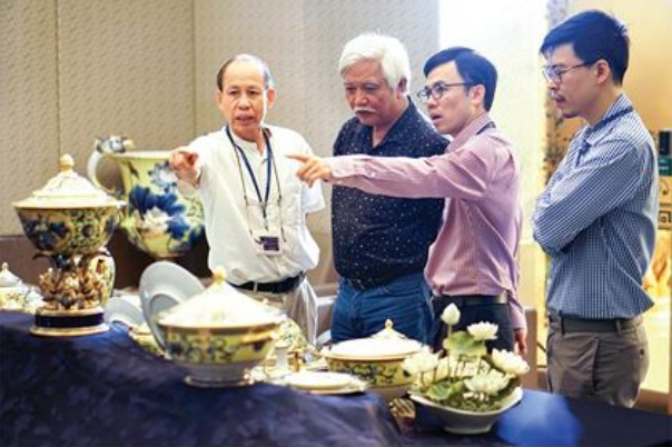 Ông Lý Ngọc Minh cùng nhà sử học Dương Trung Quốc (thứ hai từ trái sang) và hai con trai trao đổi về bộ sản phẩm phục vụ tại Tuần lễ Cấp cao APEC 2017.