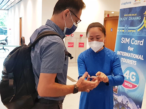 Nhân viên VNPT Đà Nẵng hướng dẫn du khách nước ngoài cài đặt sim data 4G Vinaphone được tặng miễn phí