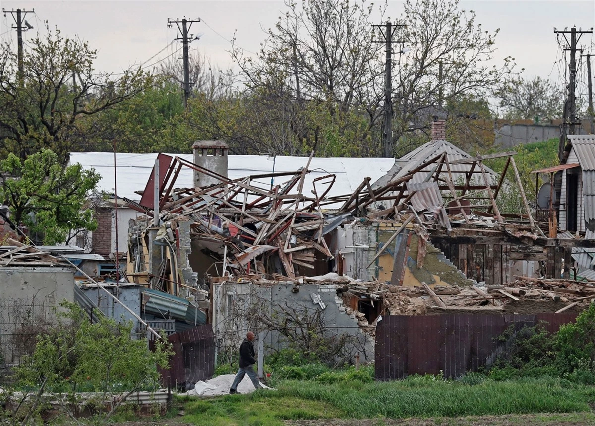 Một người dân địa phương đi ngang qua những ngôi nhà bị phá hủy ở Mariupol, Ukraine, vào ngày 5/5. Ảnh: Reuters