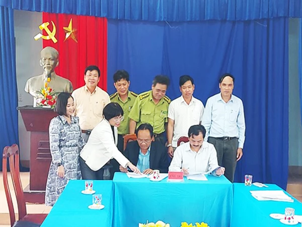 Giám đốc Sở NN-PTNT Đà Nẵng Nguyễn Phú Ban (áo vest xanh) trực tiếp ký kết bàn giao diện tích chồng lấn tại khu vực Cà Nhông cho UBND huyện Đông Giang (Quảng Nam) quản lý