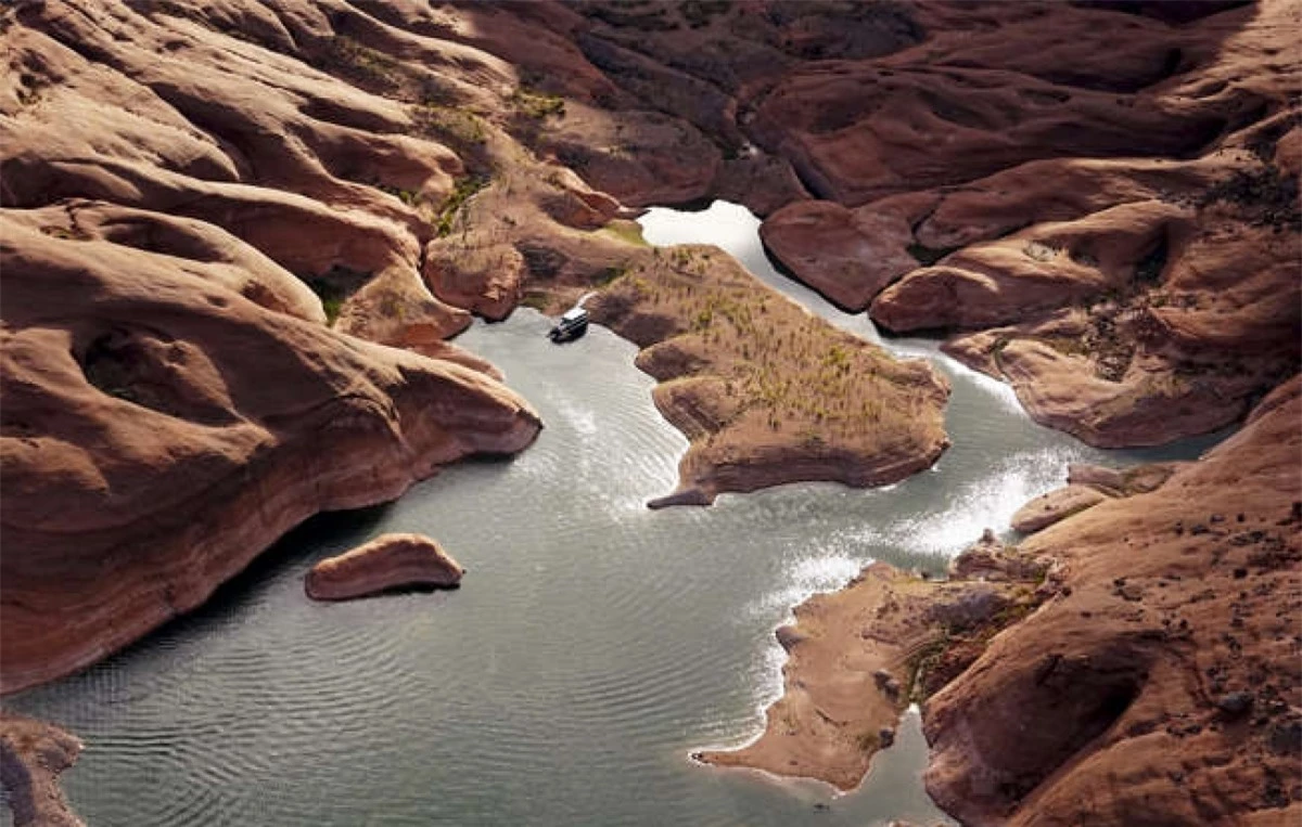 Một con thuyền ở sát mép bờ của vùng nước nông trong một hẻm núi ở Hồ Powell gần Page, Arizona. Hồ nước này, nằm trên dòng sông Colorado đã cung cấp nước cho các bang Nevada, Arizona và California.