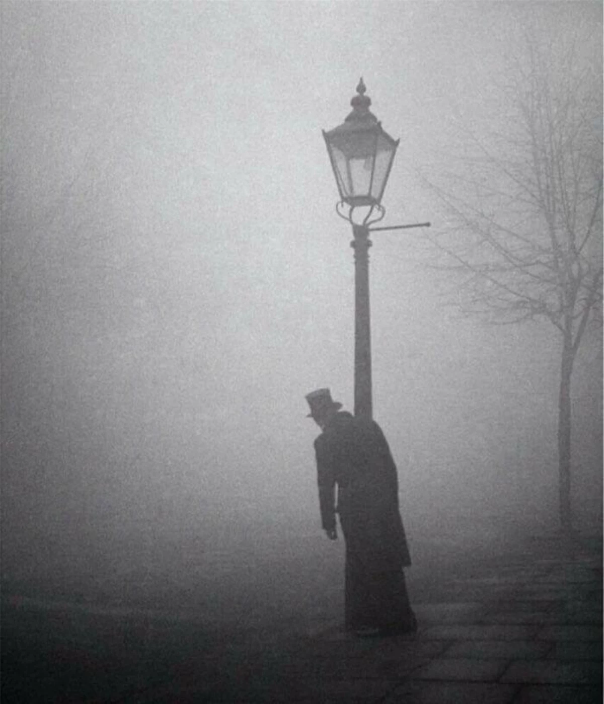 Một người đàn ông say xỉn đứng dưới một cột đèn ở London năm 1934.