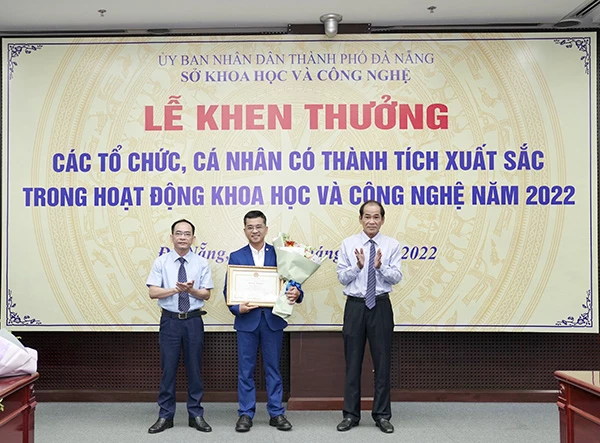 TS Lê Đức Viên, Giám đốc Sở KH&CN Đà Nẵng (tráo) và ông ông Thái Bá Cảnh, Phó chủ tịch Liên hiệp các Hội Khoa học và Kỹ thuật trao bằng khen và hoa chúc mừng cho tác giả có thành tích xuất sắc trong hoạt động KH&CN 