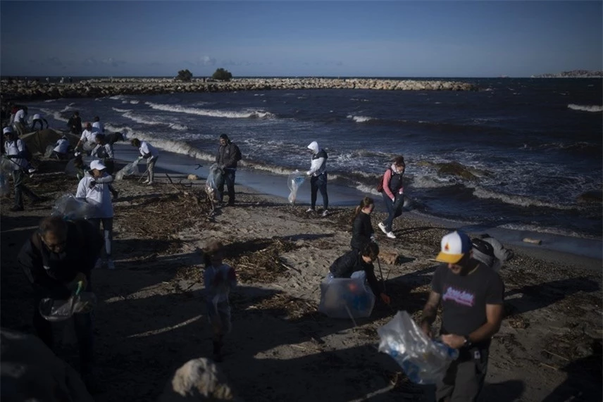 Các tình nguyện viên làm sạch một bãi biển khỏi rác thải bị cuốn trôi bởi một cơn bão ở Marseille, miền nam nước Pháp. Ảnh: AP.