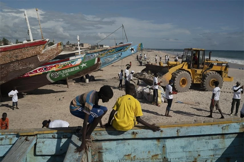 Các tình nguyện viên giúp dọn dẹp rác thải trên bãi biển nhân Ngày Thế giới làm sạch ở Bargny, Senegal. Ảnh: AP.
