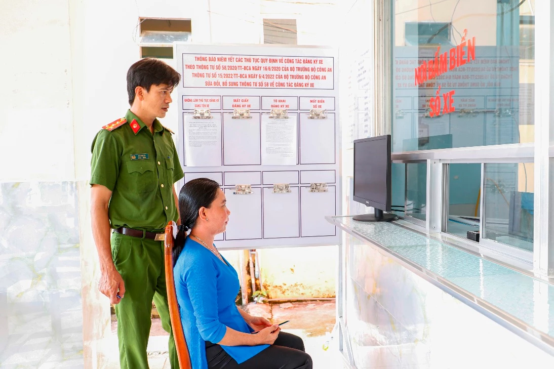 Công an hướng dẫn người dân bấm biển số xe máy tại xã Mỹ Khánh, huyện Phong Điền (TP Cần Thơ).