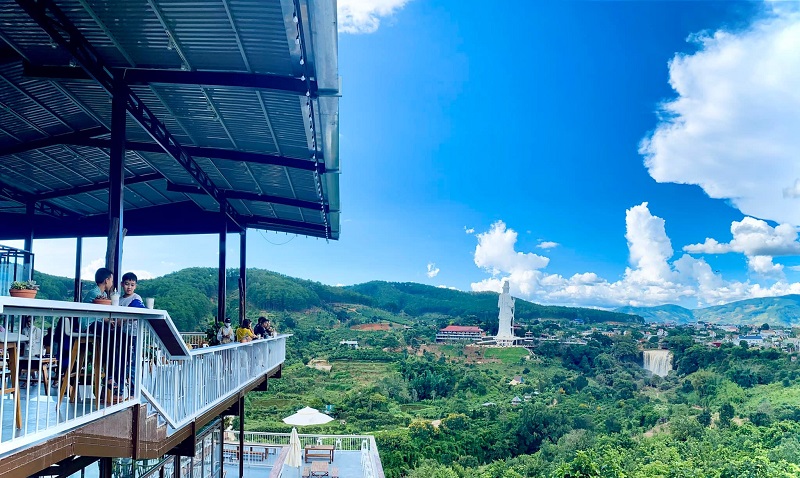 Điểm dừng chân trải nghiệm Cà phê Tám Trình có không gian thiên nhiên xanh mát với view thác Voi hùng vĩ, tượng Phật Bà cao 71 mét, kết hợp với đồi thông và núi non thơ mộng.