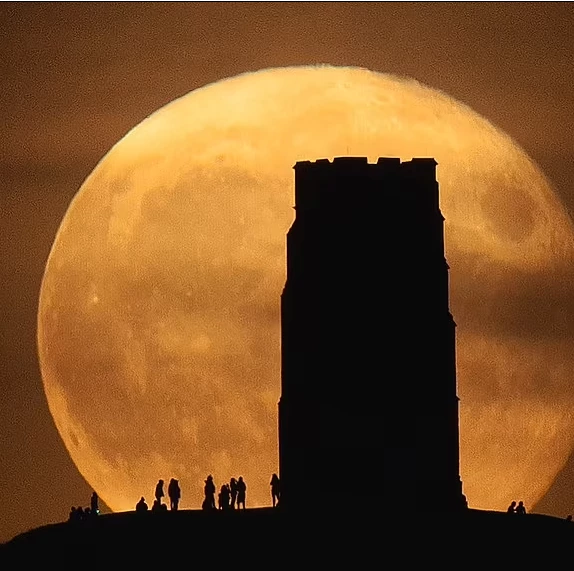 A supermoon occurs when the full moon nearly coincides with the point in its orbit at which it is nearest to the Earth. Pictured is a full moon rising behind Glastonbury Tor in September 2021