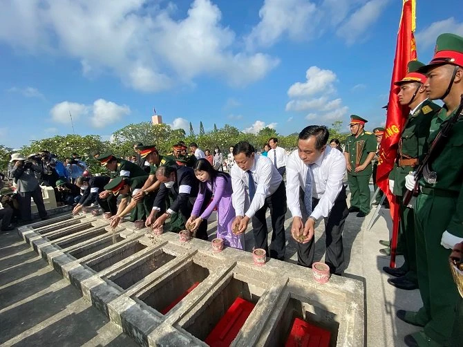 Đại biểu bỏ nắm đất cuối cùng tiễn đưa các liệt sĩ về nơi an nghĩ tại Nghĩa trang Liệt sỹ Dốc Bà Đắc.