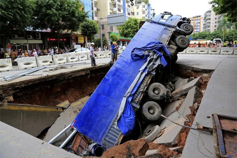 Một chiếc xe tải bị mắc kẹt trong một chiếc "hố tử thần" lớn tr&ecirc;n một con phố ở Ng&ocirc; Ch&acirc;u, Khu tự trị Choang Quảng T&acirc;y, Trung Quốc v&agrave;o ng&agrave;y ng&agrave;y 14/8/2014. Ảnh: Reuters.