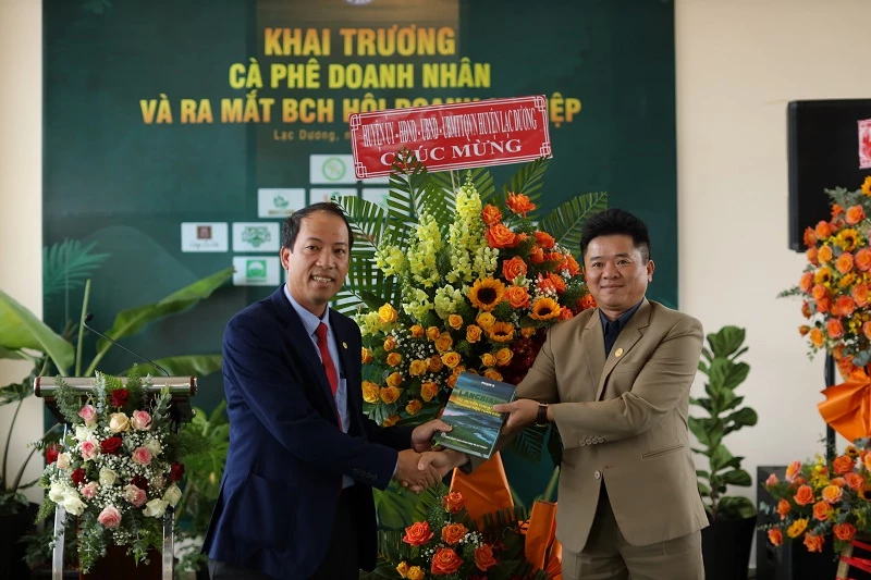 Ông Sử Thanh Hoài (bên trái) - Chủ tịch UBND huyện Lạc Dương, tặng hoa chúc mừng và cuốn sách quý viết về vùng đất LangBiang cho Chủ tịch Chi hội Doanh nghiệp Lạc Dương.