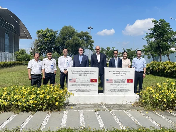 Đại sứ Hoa Kỳ tại Việt Nam Marc E.Knapper và đoàn công tác chụp ảnh lưu niệm với lãnh đạo Cảng HKQT Đà Nẵng tại bBia đá ghi nhớ Dự án xử lý môi trường ô nhiễm Dioxin sân bay Đà Nẵng