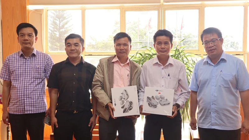 Bí thư Huyện uỷ Đức Trọng Nguyễn Ngọc Phúc (bìa phải) cùng đại diện UBND huyện và doanh nghiệp trao tặng thiết bị flycam cho 2 Ban quản lý rừng phòng hộ.
