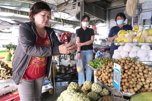 Người dân mua hàng trả tiền mua hàng bằng cách quyét mã QR.