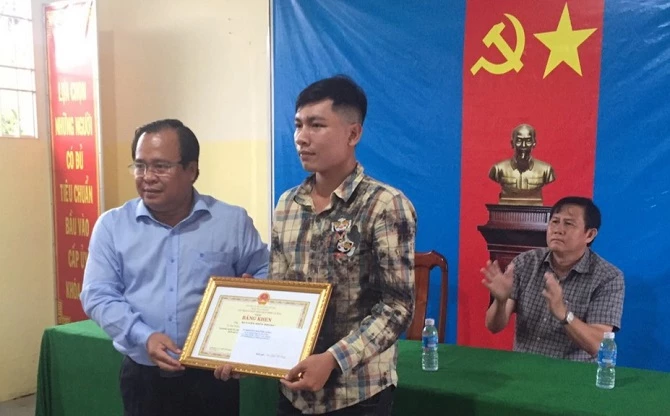 Ông Nguyễn Minh Luân trao bằng khen của Chủ tịch UBND tỉnh cho anh Nguyễn Hiền Phong