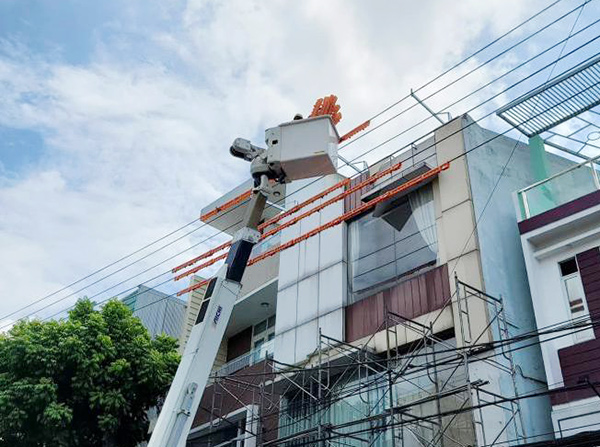 Đội Sửa chữa nóng lưới điện PC Đà Nẵng tiến hành bọc cách điện đường dây trung thế để đảm bảo an toàn cho người dân xây dựng nhà ở