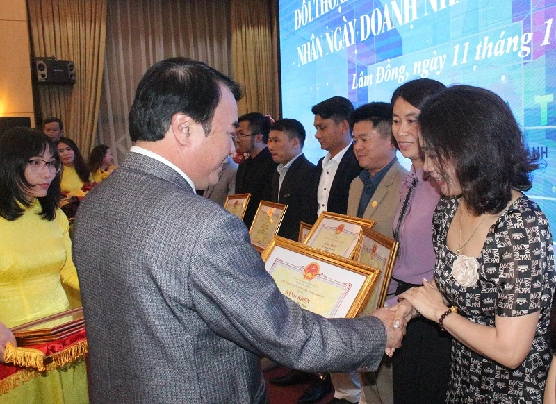 Phó Chủ tịch UBND tỉnh Lâm Đồng Phạm S trao bằng khen cho các doanh nhân. 