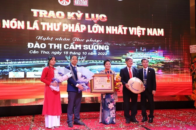 Tại buổi lễ, đại diện tổ chức kỷ lục Việt Nam trao kỷ lục Nón lá thư pháp lớn nhất Việt Nam cho nghệ nhân thư pháp Đào Thị Cẩm Sương    