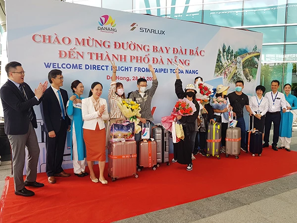 Lãnh đạo Trung tâm Xúc tiến du lịch Đà Nẵng và Cảng Hàng không quốc tế Đà Nẵng tặng hoa chúc mừng các du khách đầu tiên từ Đài Loan trở lại Đà Nẵng trên chuyến bay JX701 của hãng hàng không Starlux sáng 28/10.