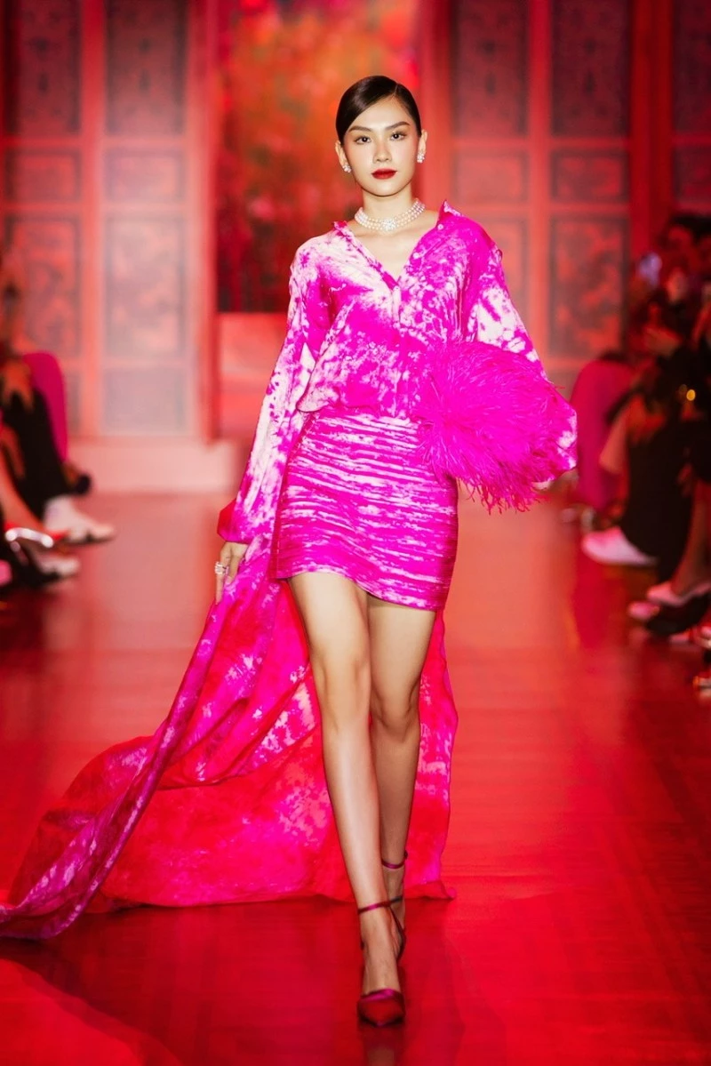 Hoa hậu Mai Phương mở màn trong bộ đầm dáng high-low, cầm trên tay chiếc túi lông vũ sang trọng.