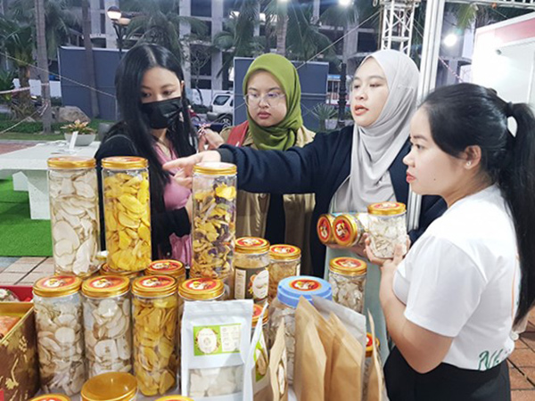Du khách nước ngoài chọn mua các sản phẩm tại Chương trình “Quảng bá sản phẩm OCOP, sản phẩm đặc trưng – Đà Nẵng năm 2022” diễn ra tại Công viên Biển Đông từ ngày 23 - 25/12