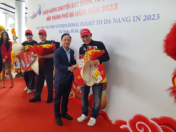 Phó Giám đốc Sở Du lịch Đà Nẵng Nguyễn Xuân Bình tặng hoa cho các vị khách quốc tế đầu tiên chuyến bay mang số hiệu VJ879 của Vietjet Air "xông đất" TP năm 2023 trên chuyến bay 