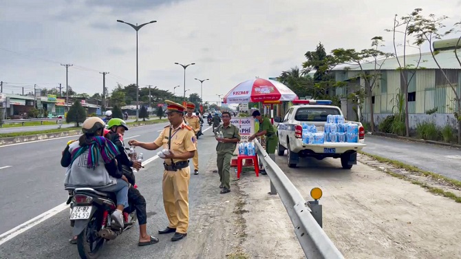 Cảnh sát giao thông Cần Thơ trao tặng nước uống cho người dân trên đường về quê đón Tết 