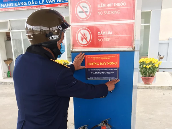 Lực luộng QLTT Đà Nẵng niêm yết số điện thoại đường dây nóng tại các cửa hàng xăng dầu trên địa bàn